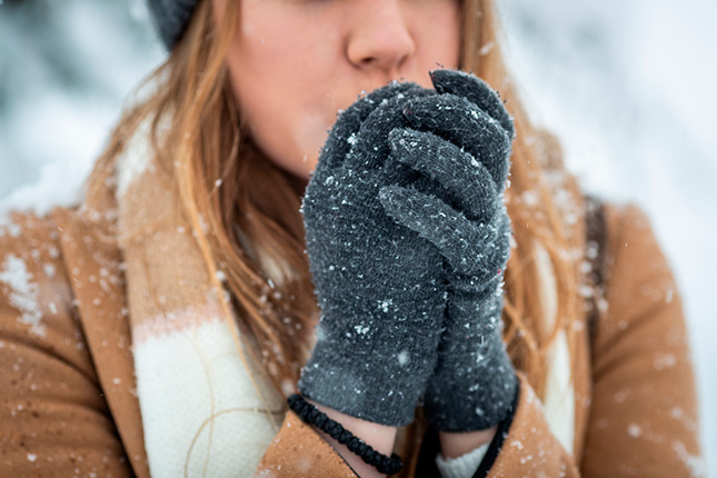 Une femme porte des gants en hiver pour protéger ses mains
